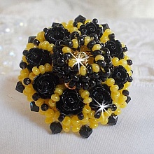 Bague Dorine brod&eacute;e avec un chaton Cristal/Dor&eacute; orn&eacute;e de roses en R&eacute;sine Noire &agrave; laquelle s&rsquo;ajoute des rocailles Jaunes et Jet mont&eacute;es en D&ocirc;me. L&rsquo;arri&egrave;re est en cuir vachette sur une bague Laiton
